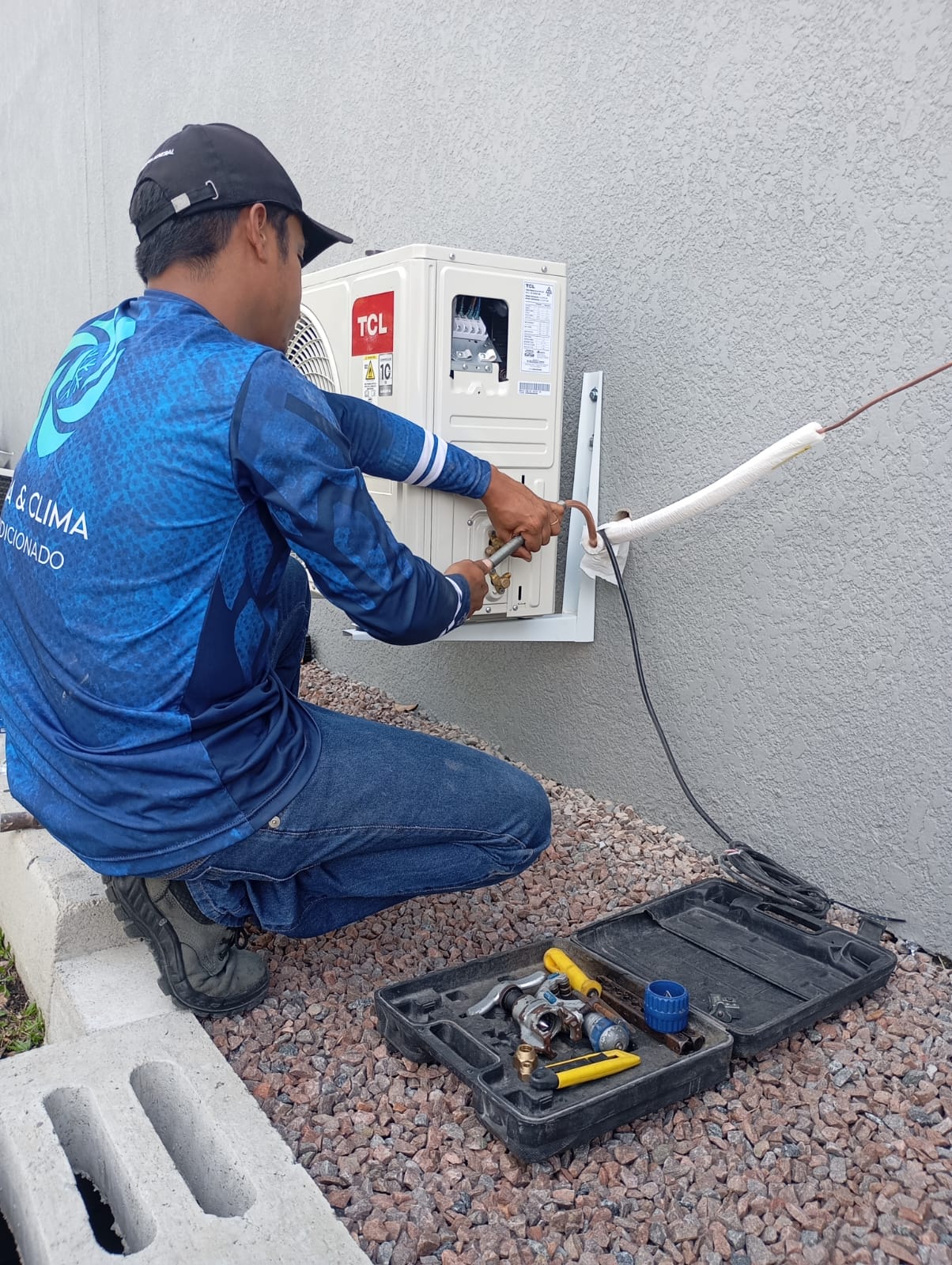 Técnico T Clima realizando manutenção em ar condicionado
